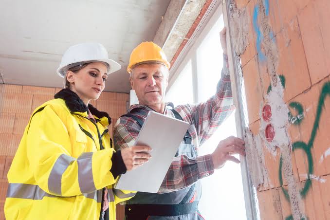Construction expert reviewing an active building project with a contractor