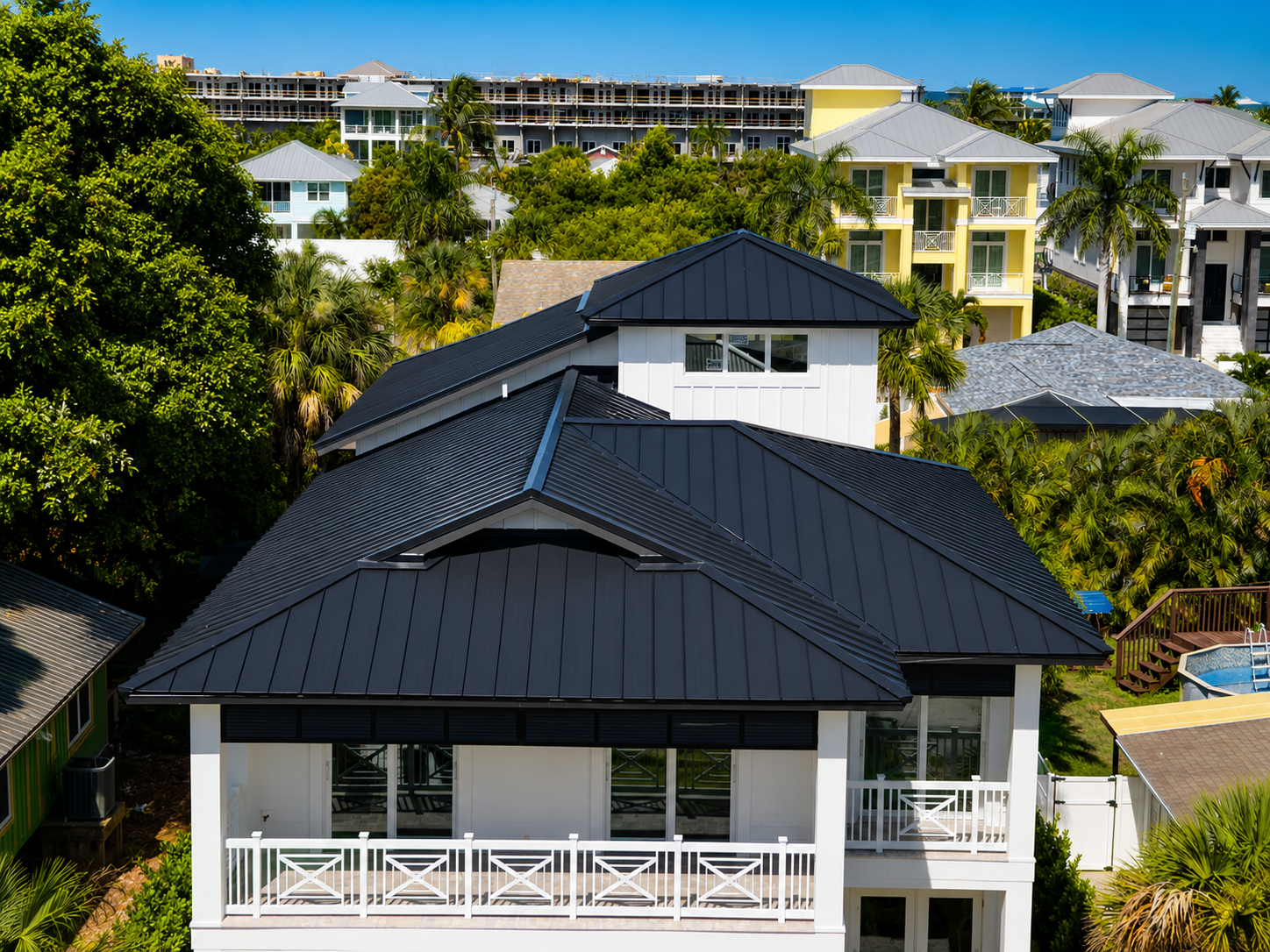 Professional roofer installing a standing seam metal roof on a modern Florida home